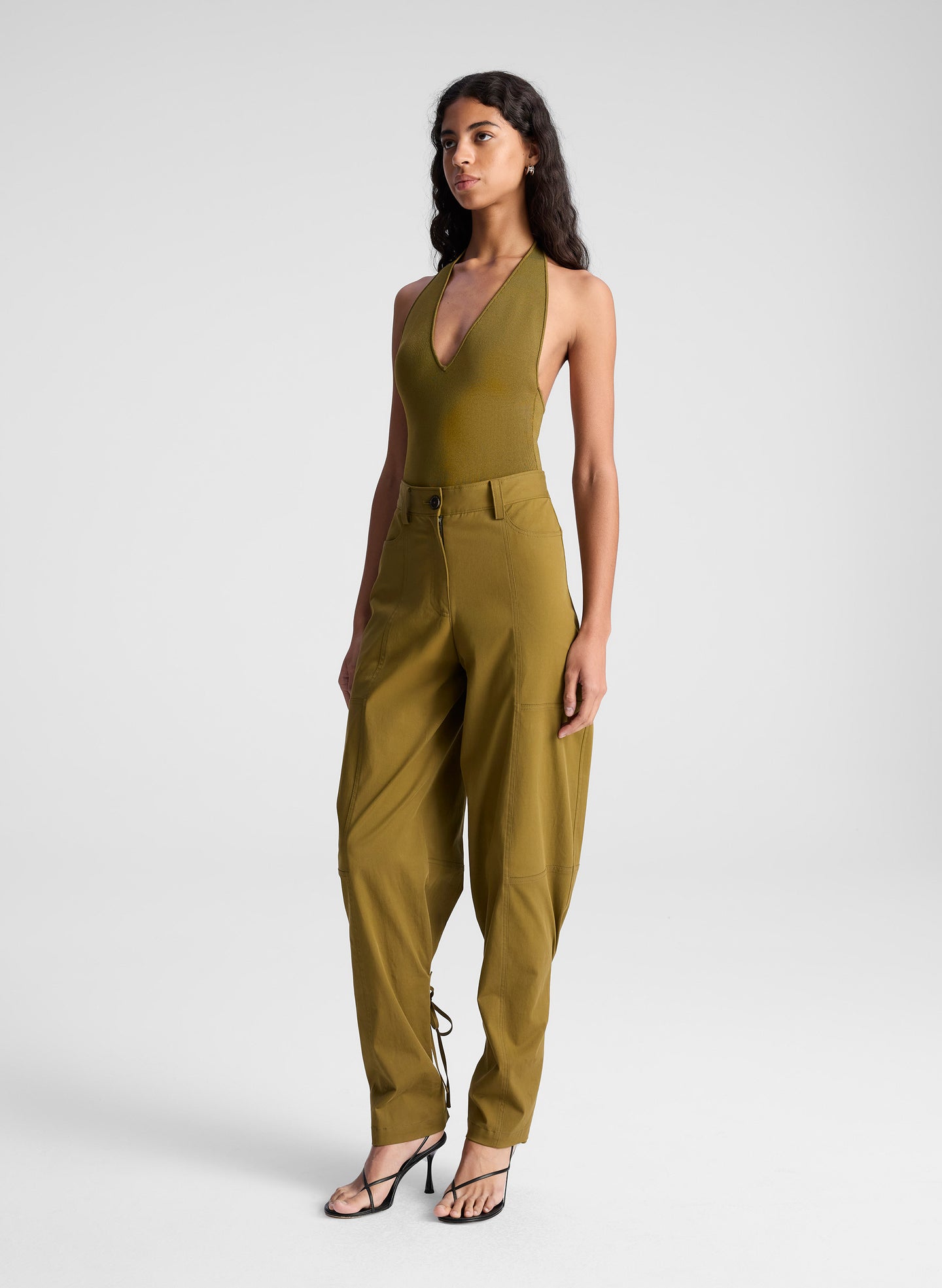 woman wearing green bodysuit and green pants