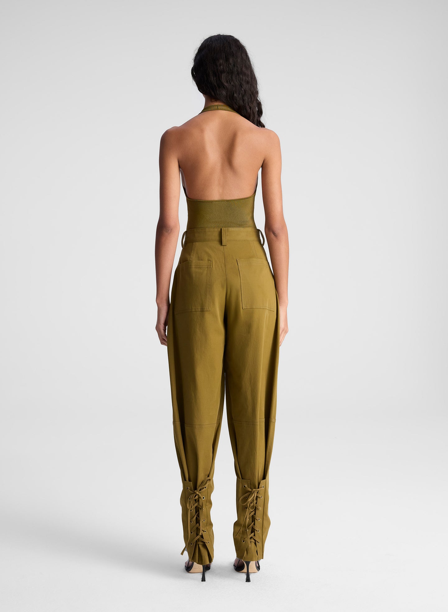 woman wearing green bodysuit and green pants