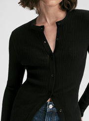 Woman wearing a black long-sleeve cardigan and blue jeans on a white background