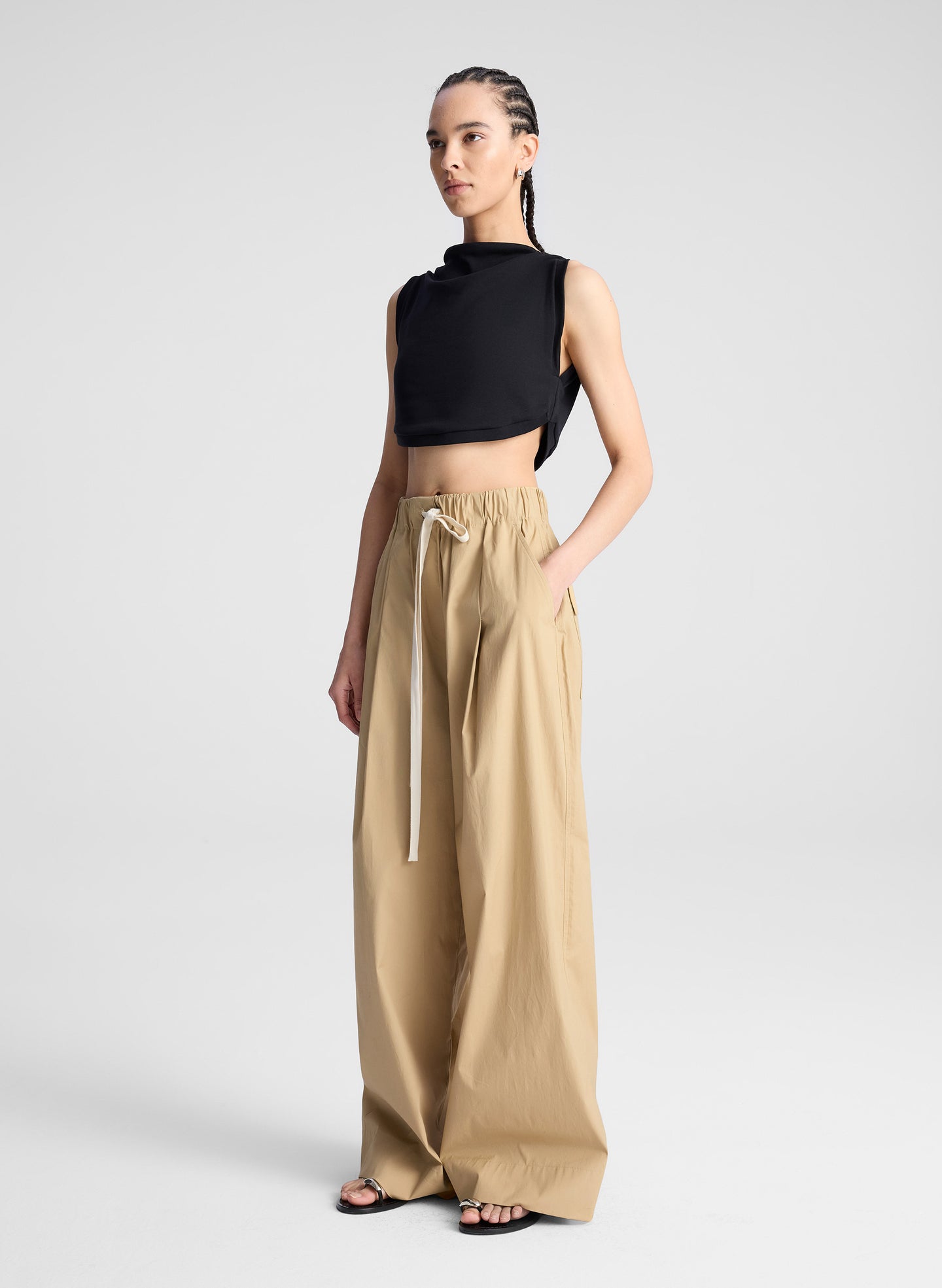 woman wearing back cropped tank and beige wide leg pants