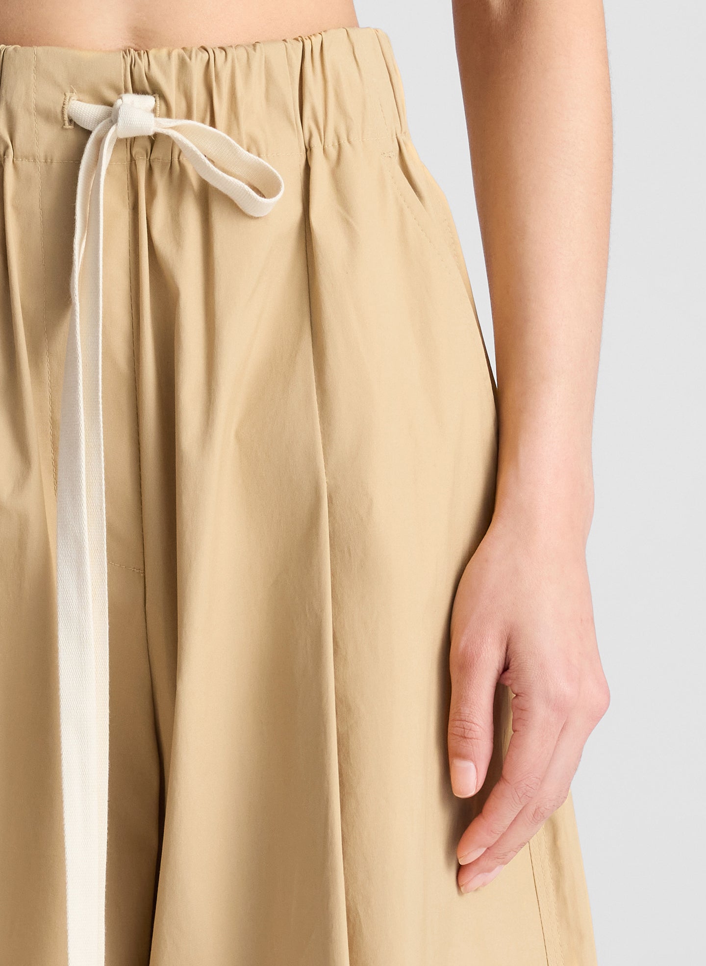 woman wearing back cropped tank and beige wide leg pants