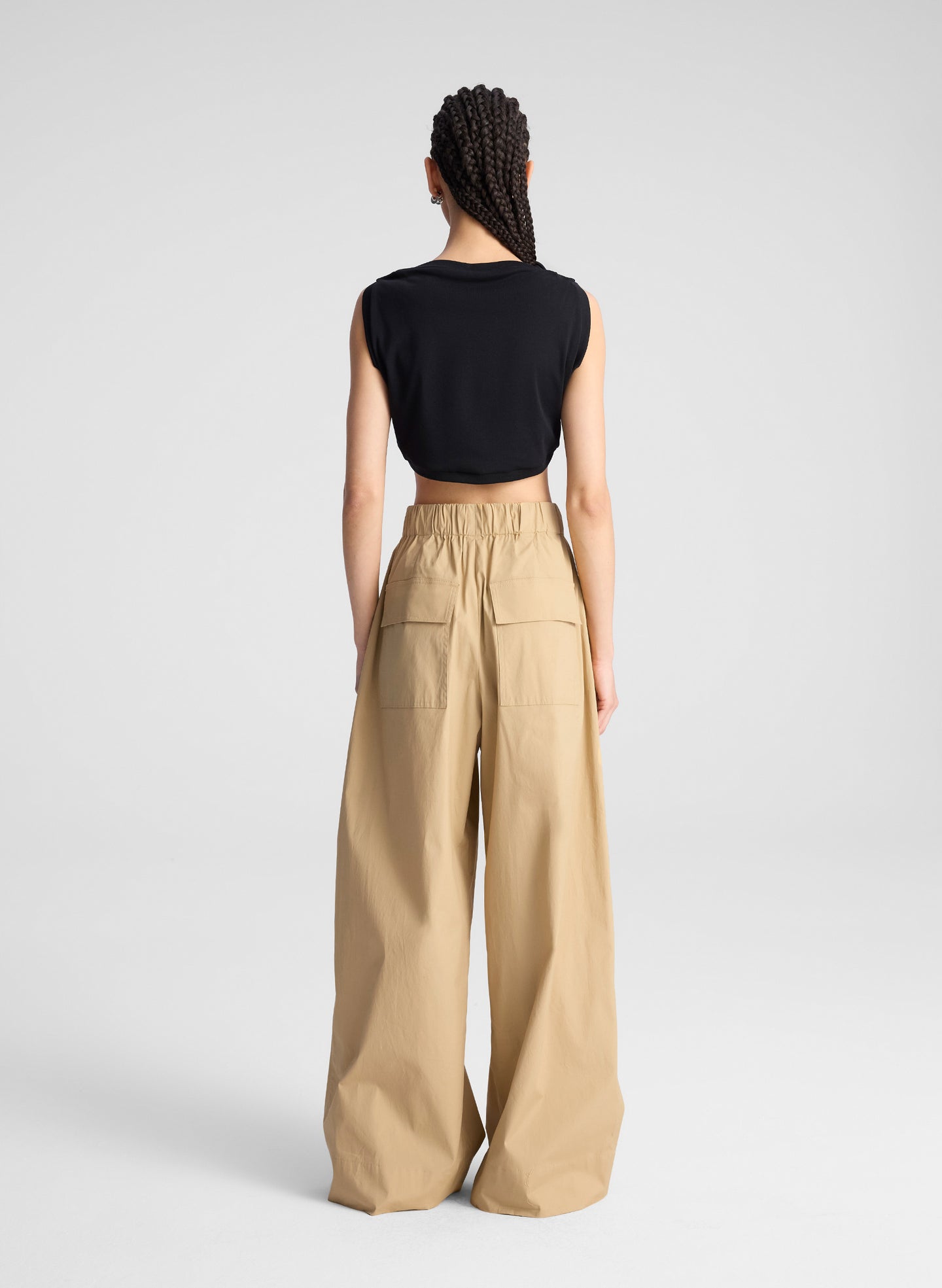 woman wearing back cropped tank and beige wide leg pants