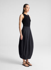 woman wearing black beaded embellishment tank top and black midi skirt