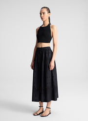 woman wearing black tank top and black eyelet skirt