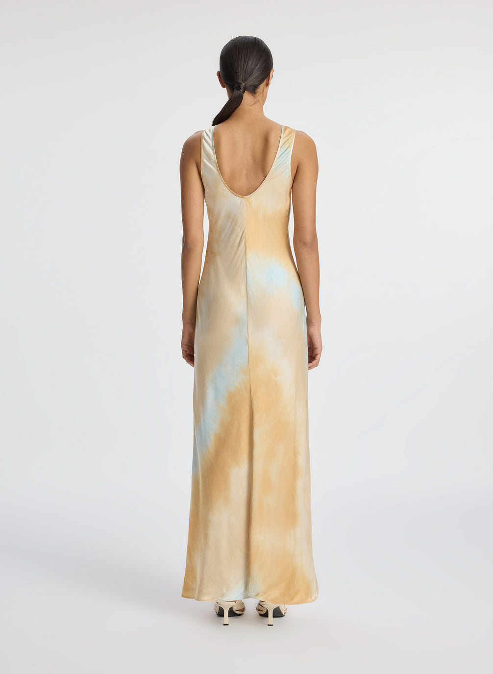 back view of woman wearing blue and beige maxi sleeveless satin dress]