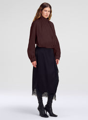 woman in dark brown jacket and black lace trim midi skirt