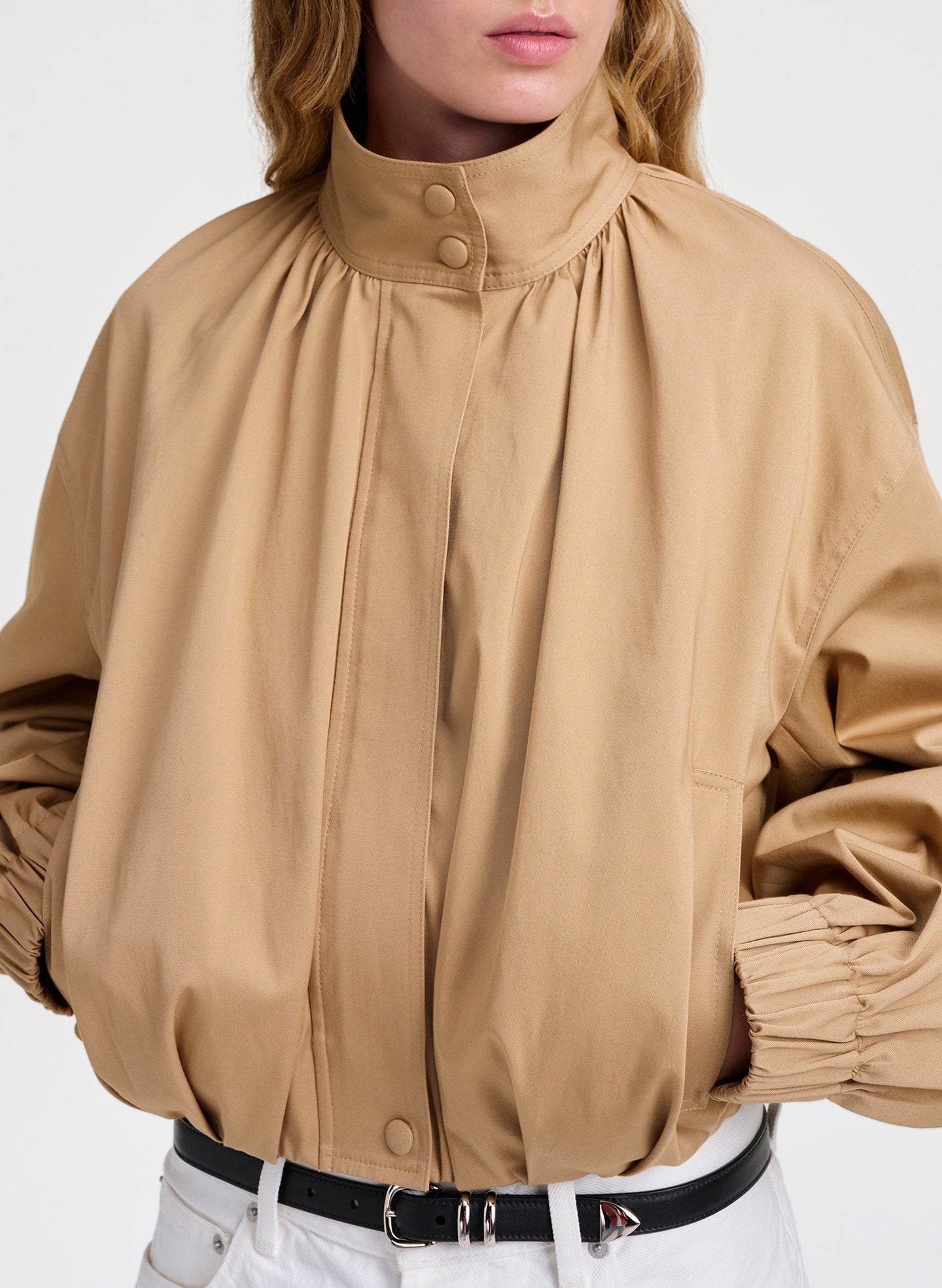 Beige jacket with a high collar and long sleeves on a white background