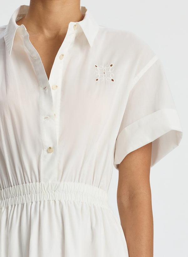 detail view of woman wearing white embroidered short sleeve maxi dress