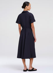 Woman wearing a navy dress on a white background