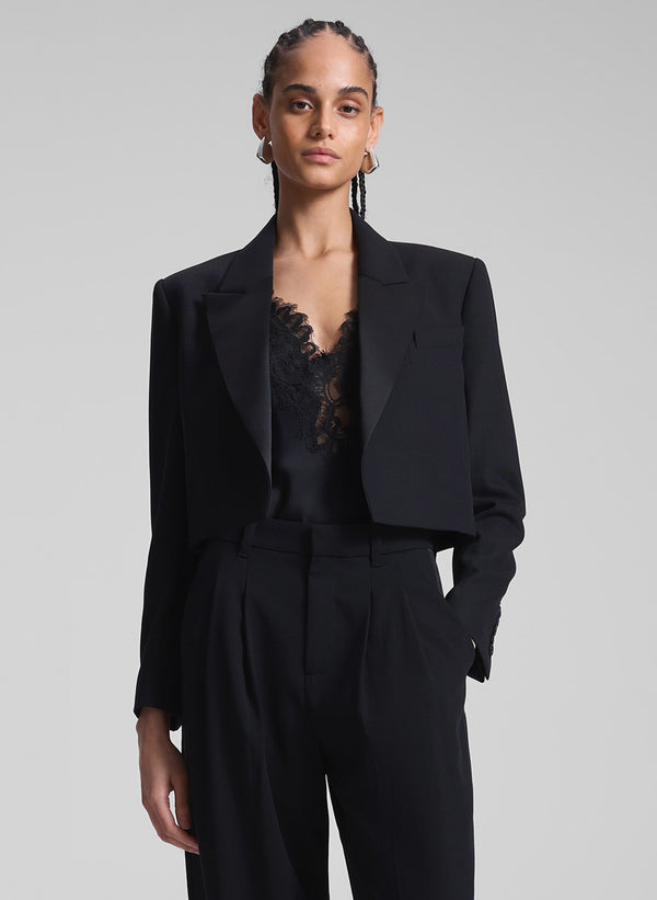 woman wearing black cropped tux jacket, black camisole, and black pants