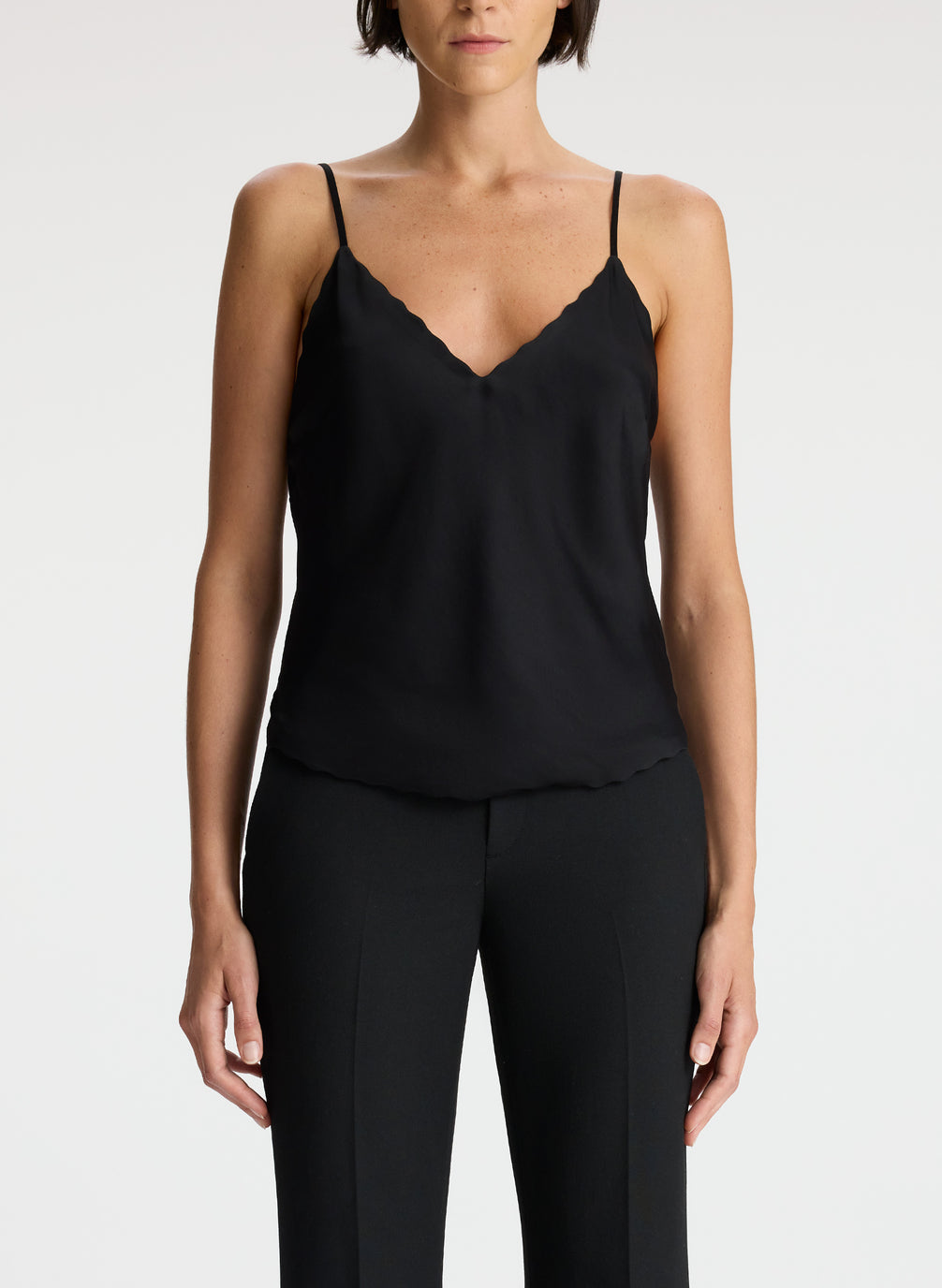 detail view of woman wearing black camisole and black flared pants