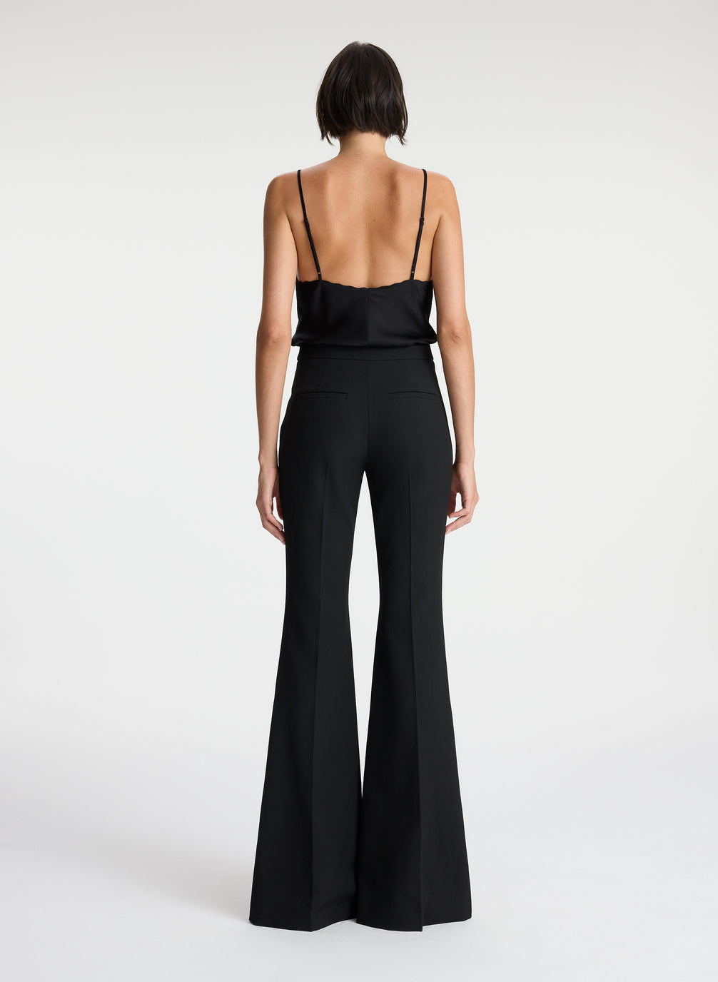 back  view of woman wearing black camisole top and black flared pants