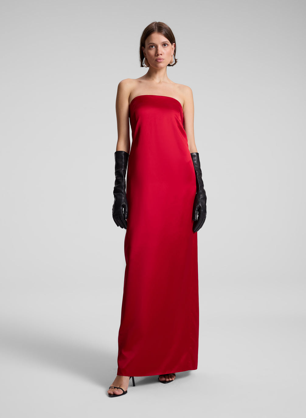 woman wearing red strapless gown and black leather gloves