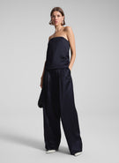 woman wearing navy blue strapless satin top and matching wide leg pants