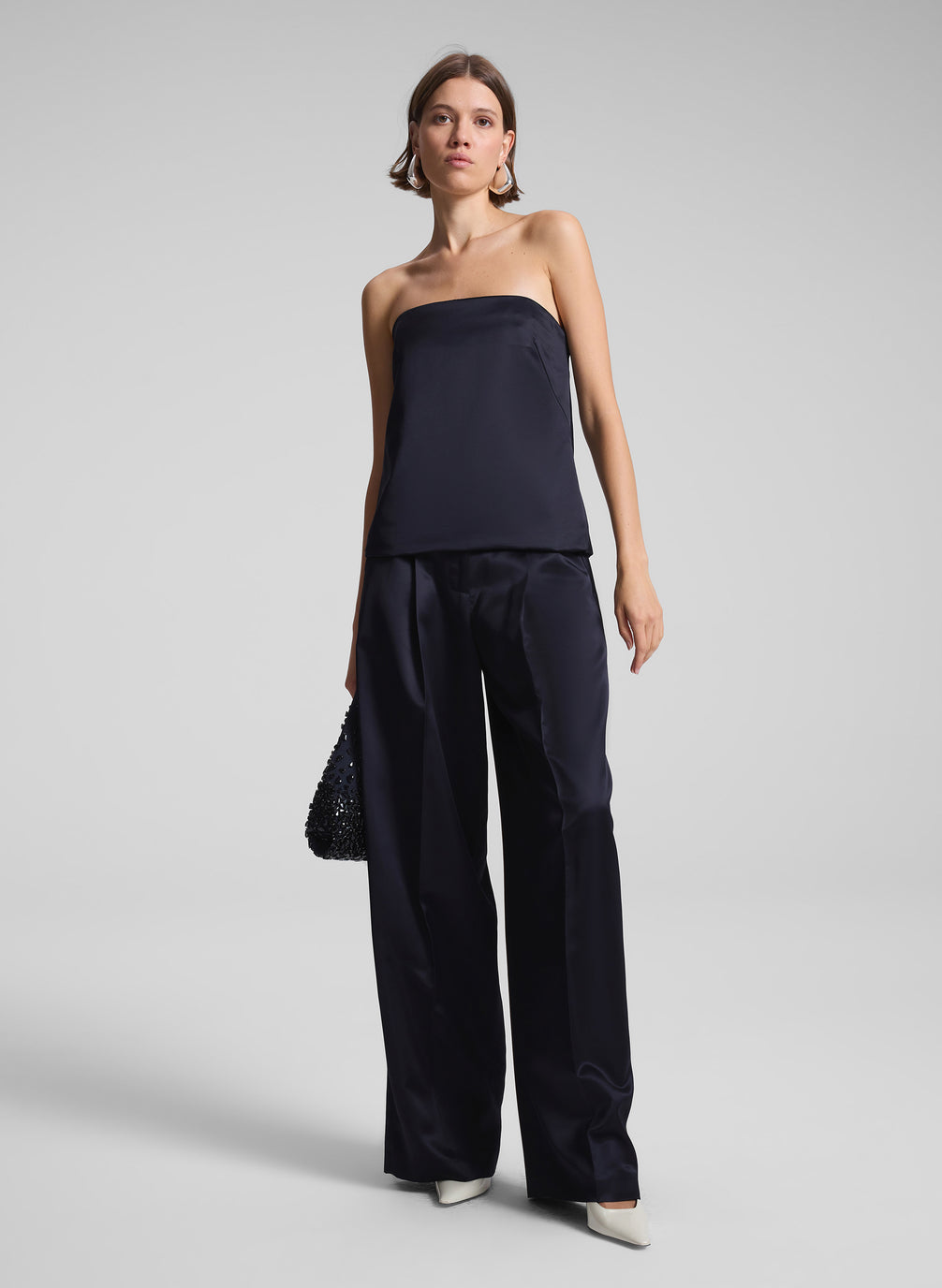 woman wearing navy blue strapless satin top and matching wide leg pants