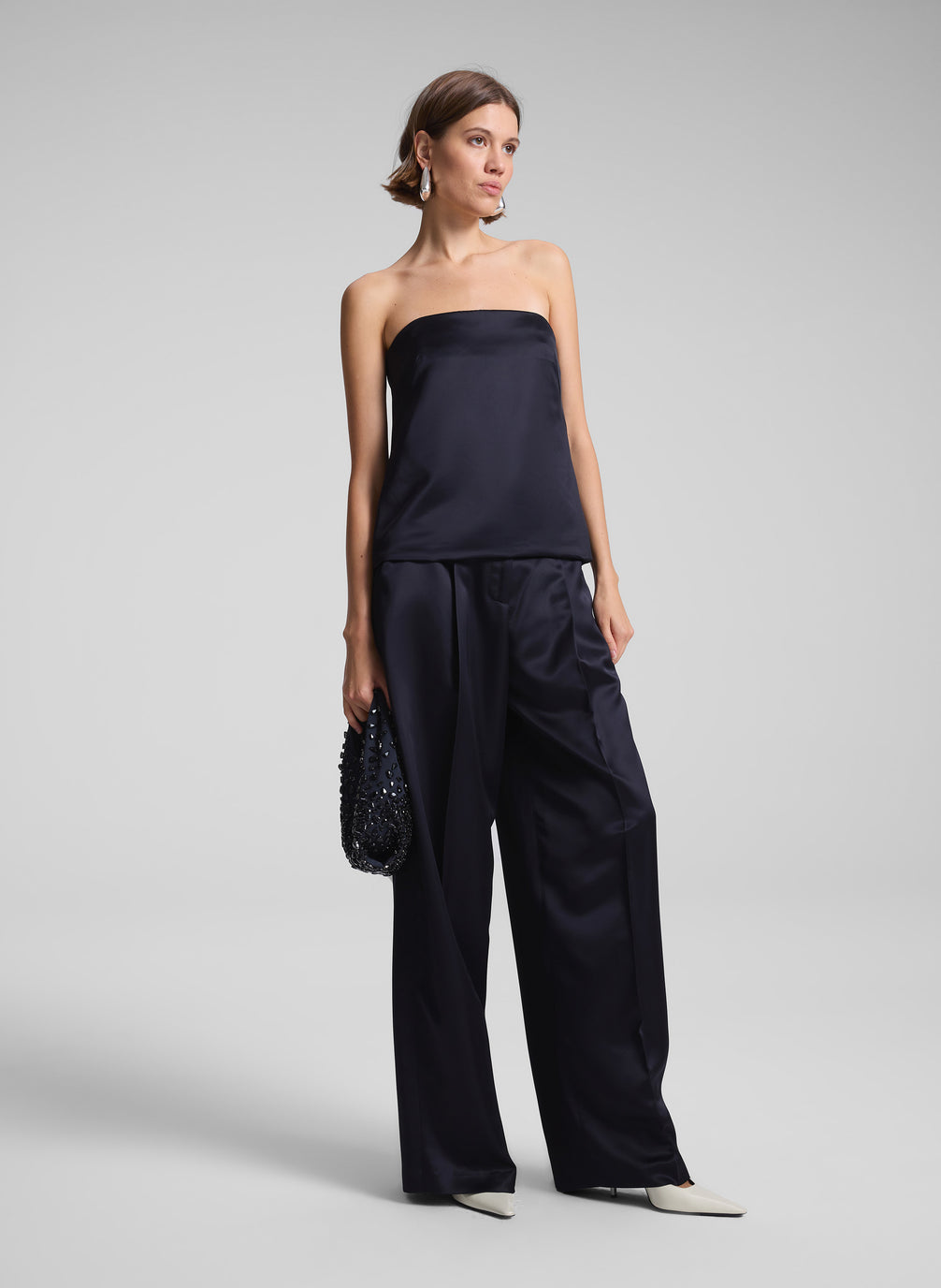 woman wearing dark blue satin strapless top and matching pants