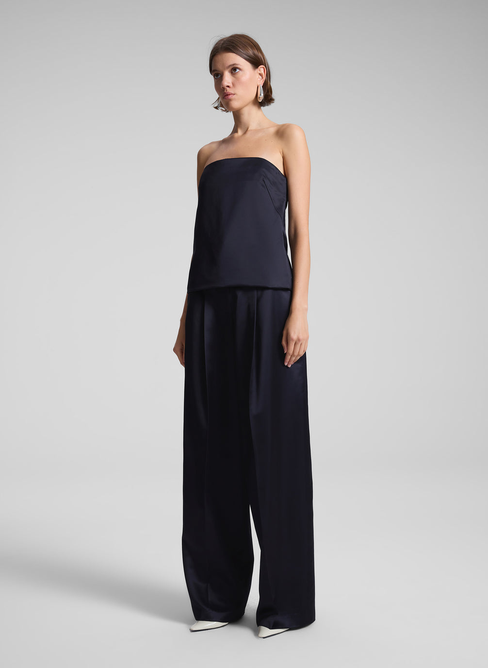 woman wearing dark blue satin strapless top and matching pants