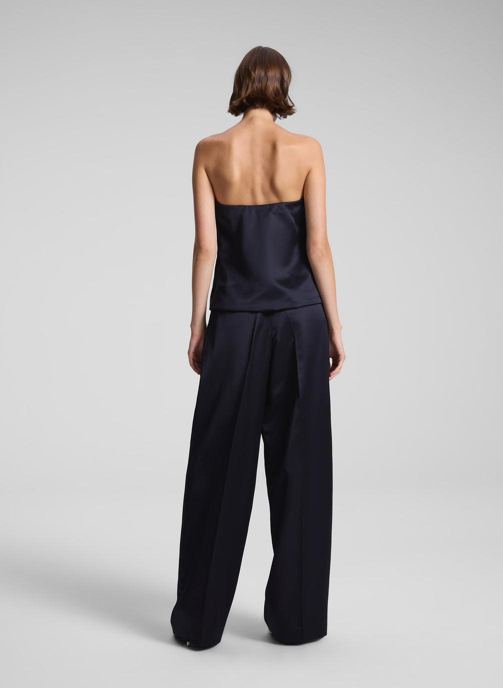 woman wearing dark blue satin strapless top and matching pants