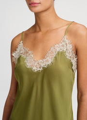 Green satin camisole with lace detailing on a white background