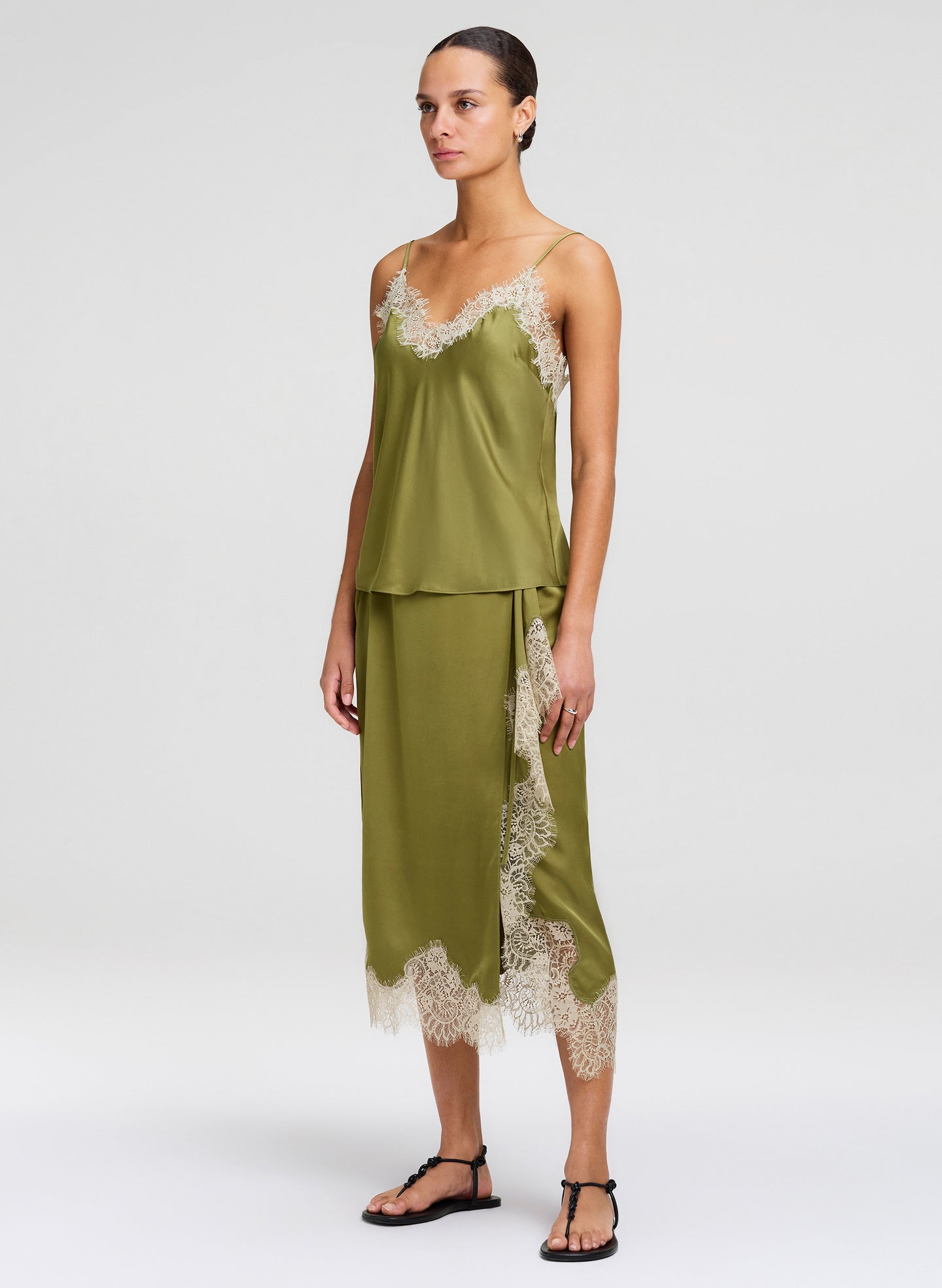 Woman wearing a green lace-trimmed outfit on a white background