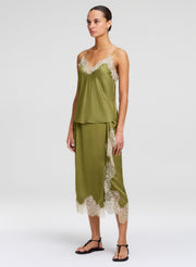 Woman wearing a green lace-trimmed outfit on a white background