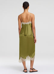 Woman wearing a green dress with lace details on a white background