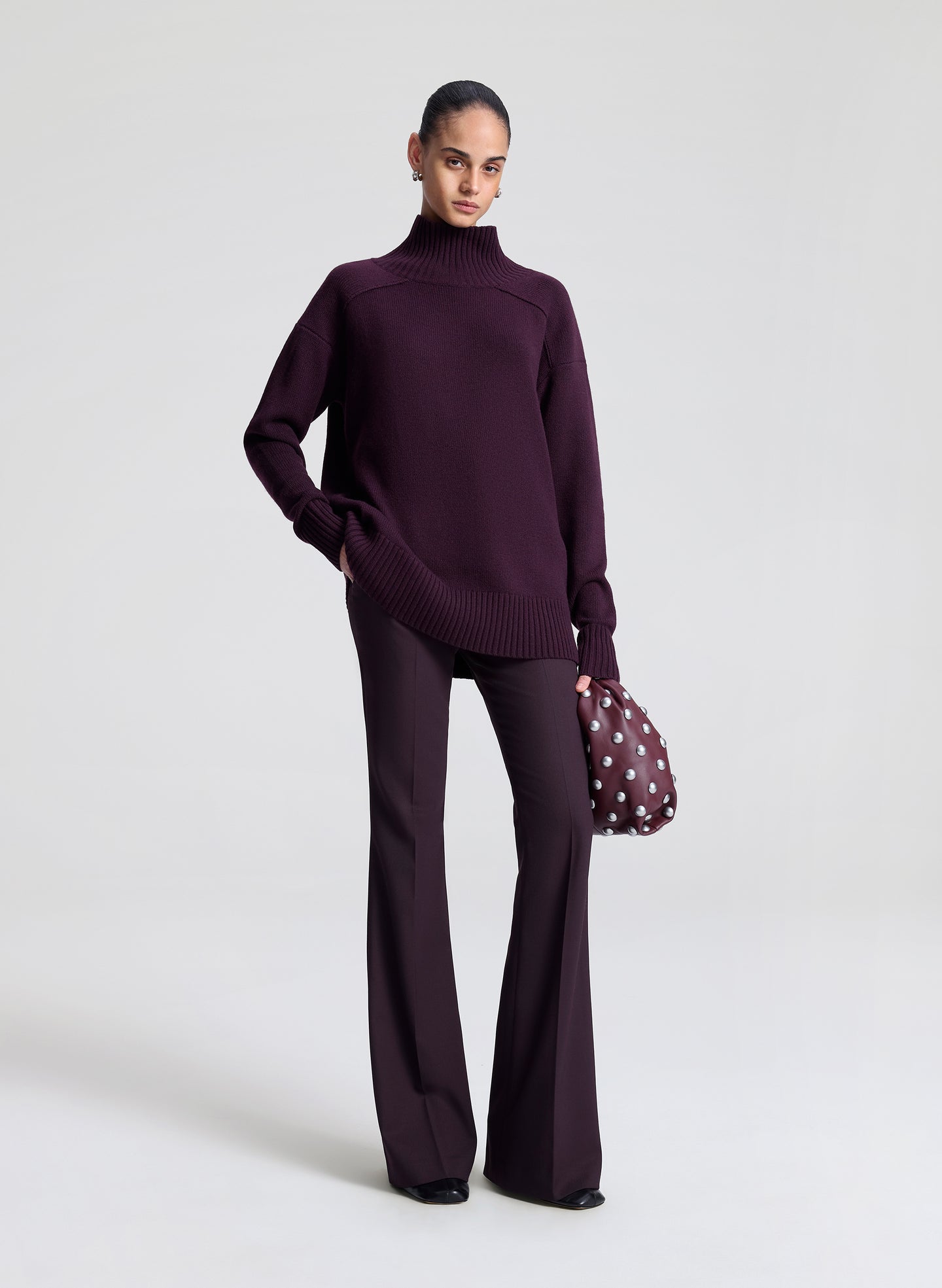 woman carrying purple studded handbag