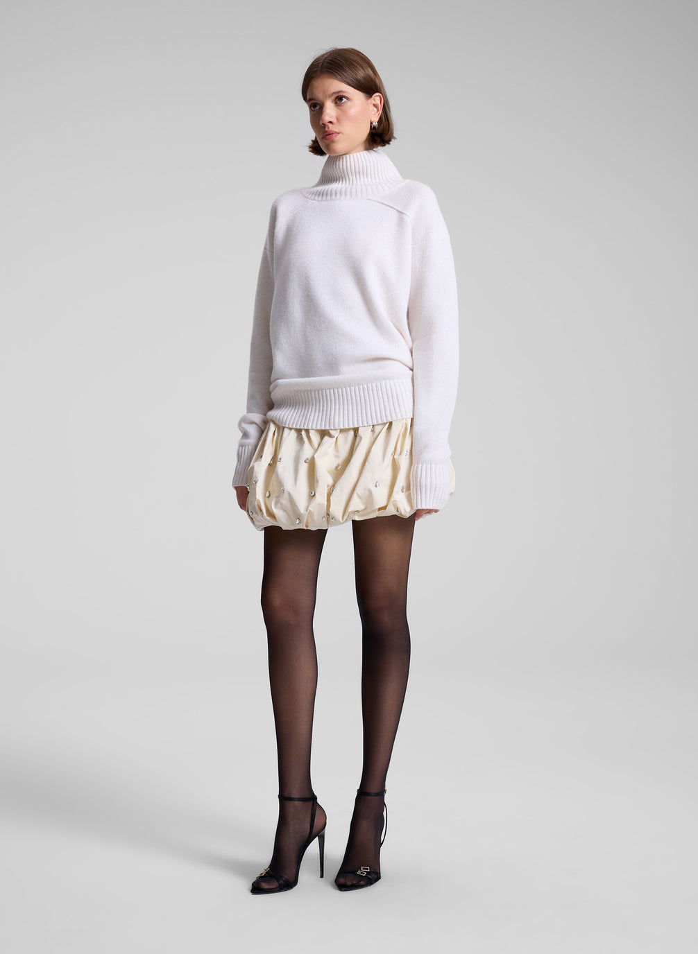 woman wearing white sweater and embellished mini skirt