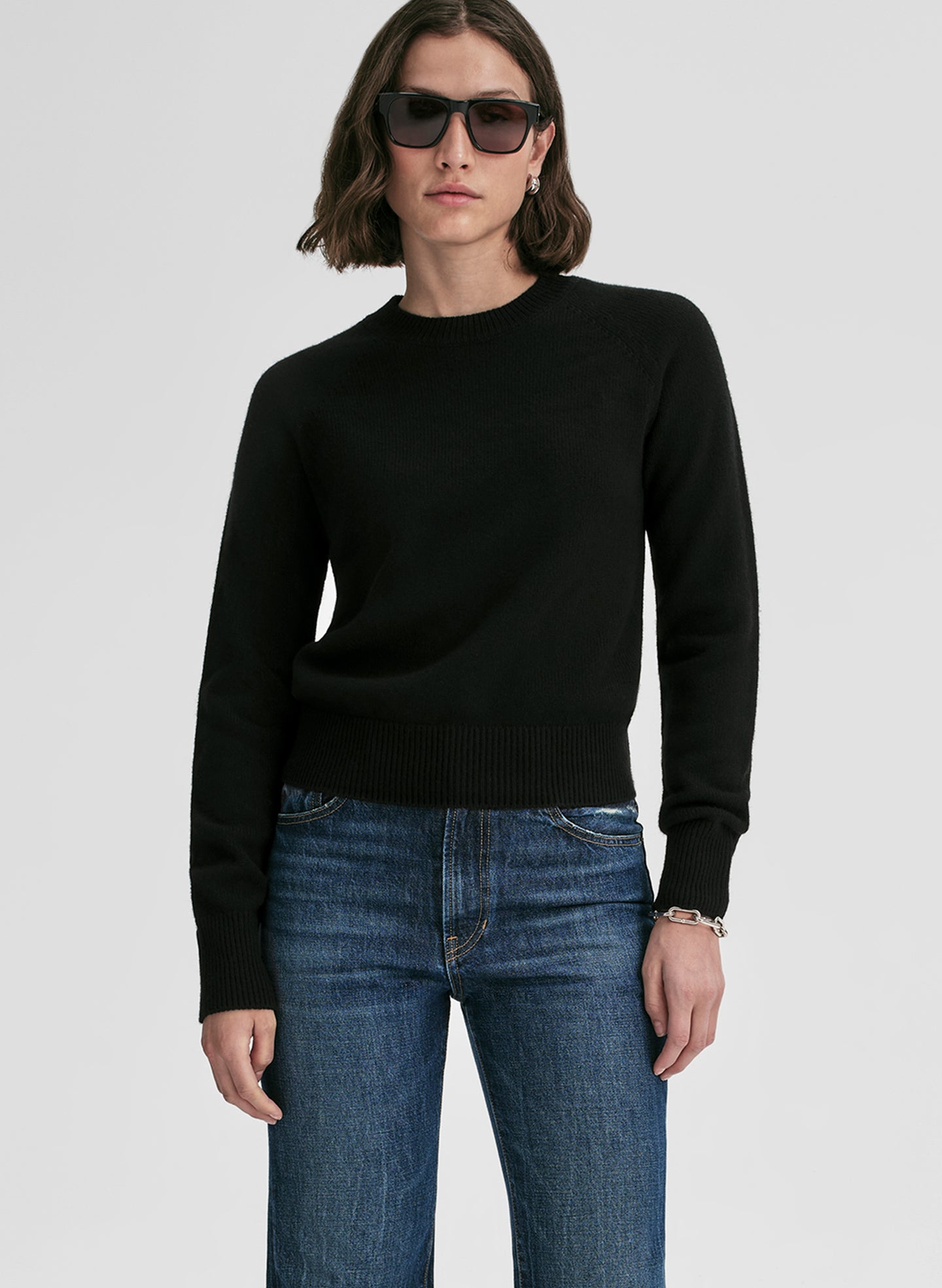 woman wearing black cashmere sweater and blue jeans
