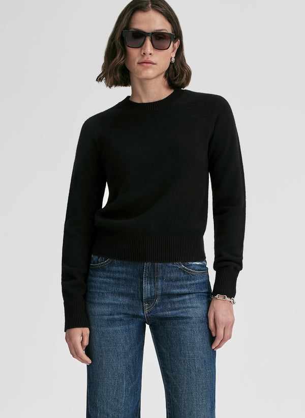woman wearing black cashmere sweater and blue jeans