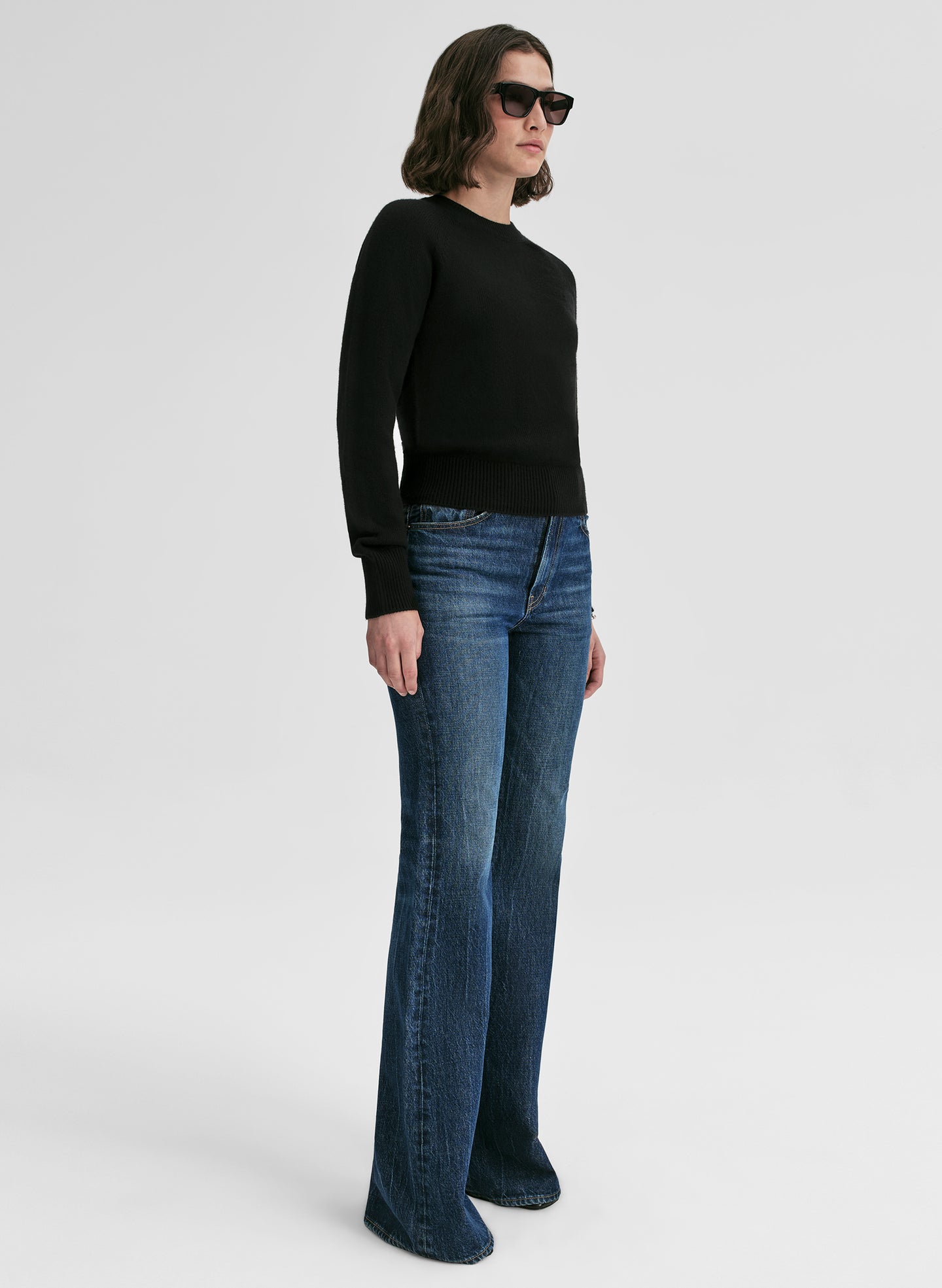 woman wearing black cashmere sweater and blue jeans