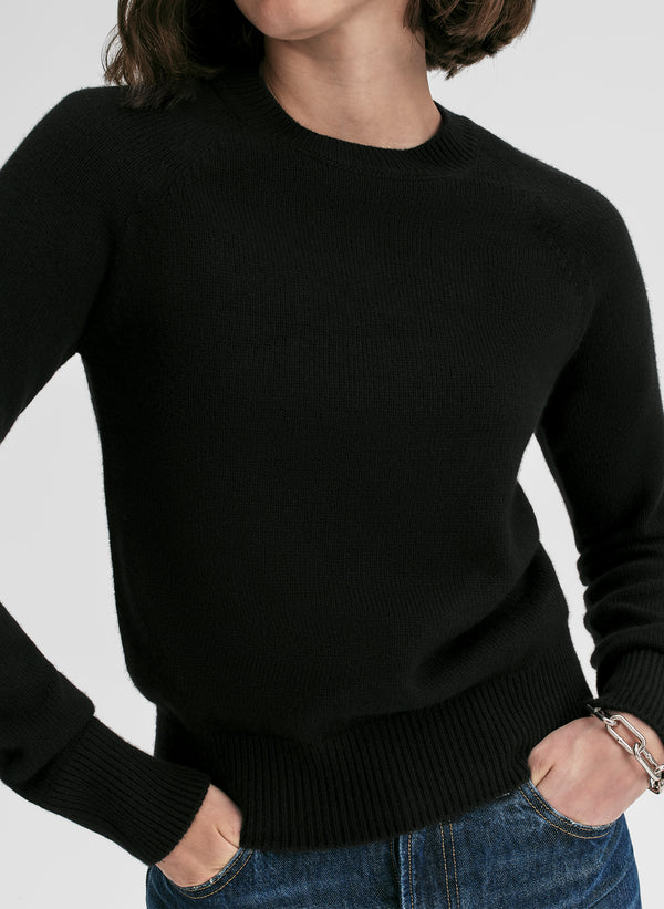 woman wearing black cashmere sweater and blue jeans