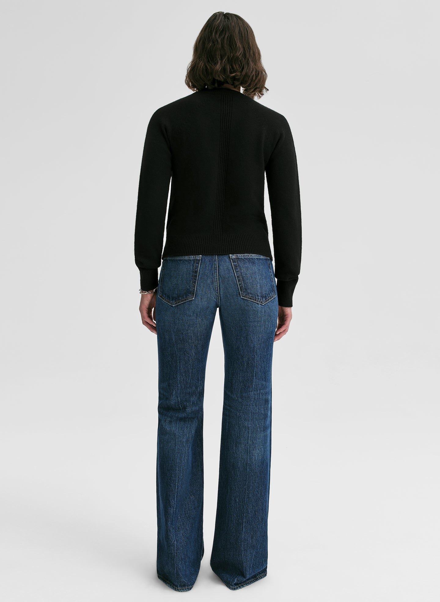 woman wearing black cashmere sweater and blue jeans