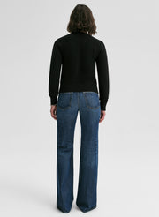 woman wearing black cashmere sweater and blue jeans