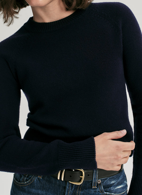 woman wearing navy blue sweater and jeans