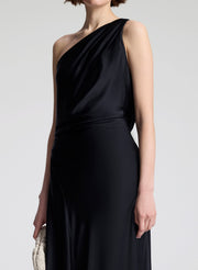 Black one-shoulder dress worn by a model on a plain background