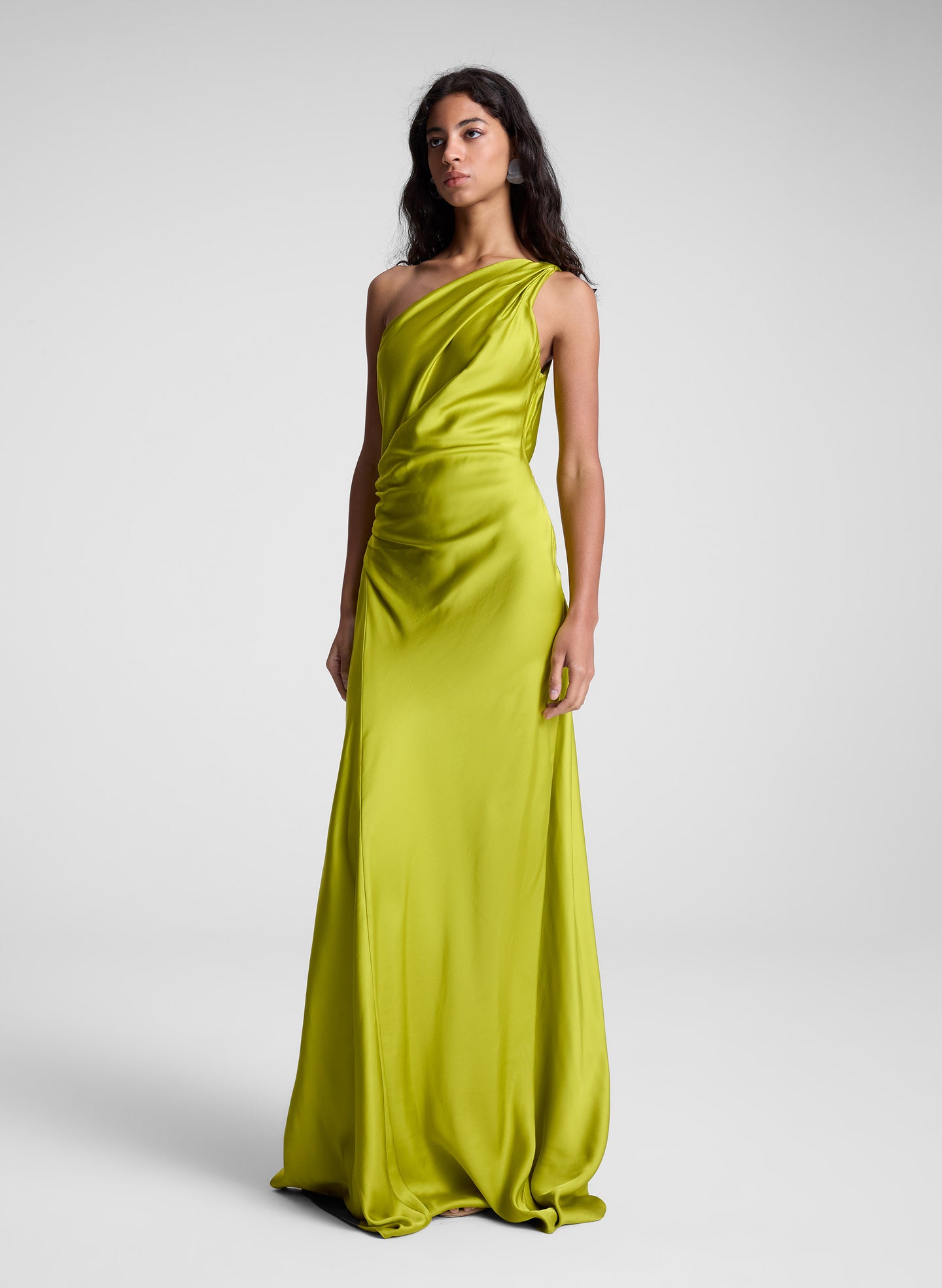 woman wearing green one shoulder maxi dress
