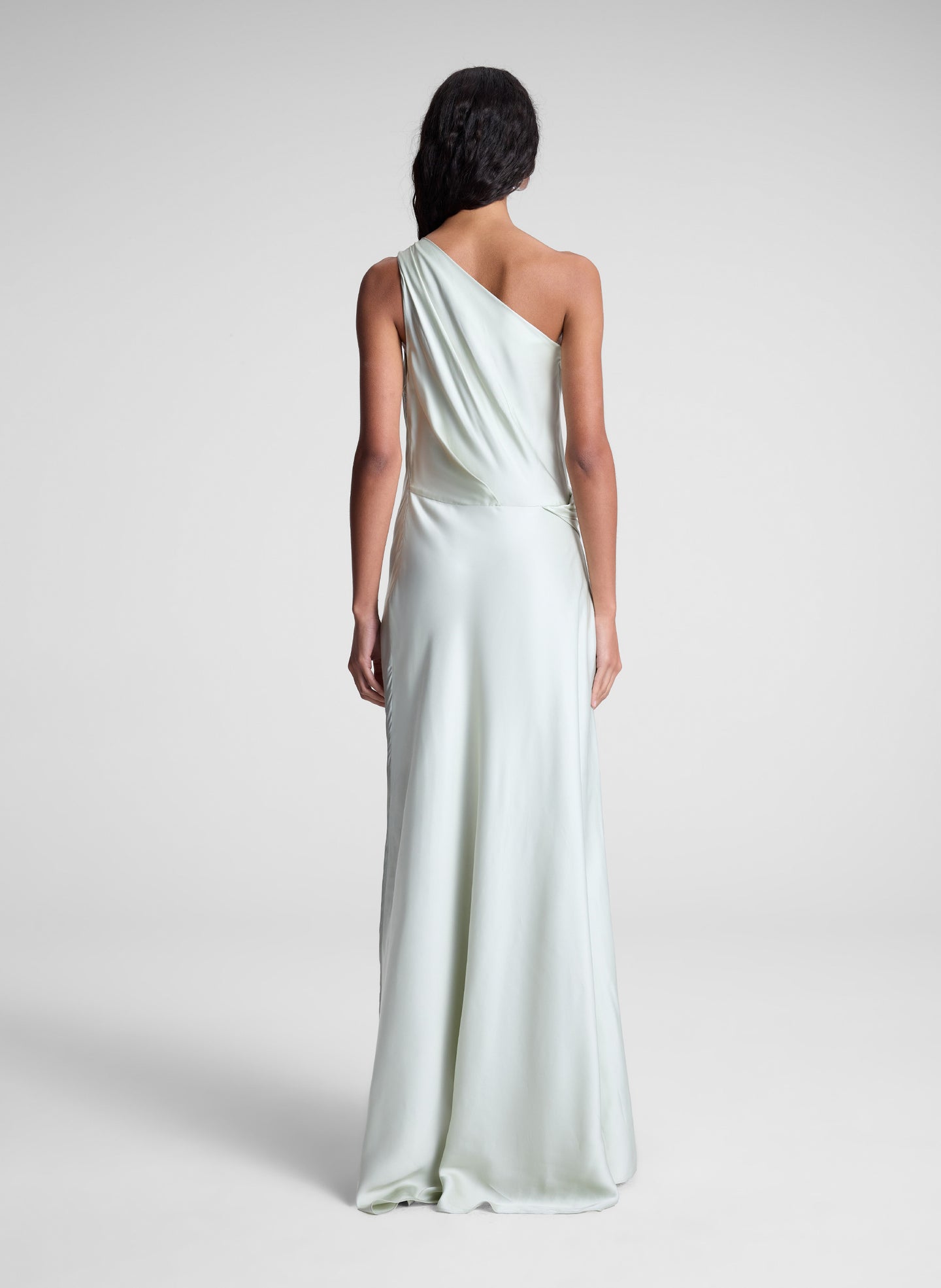 woman wearing green satin one shoulder gown