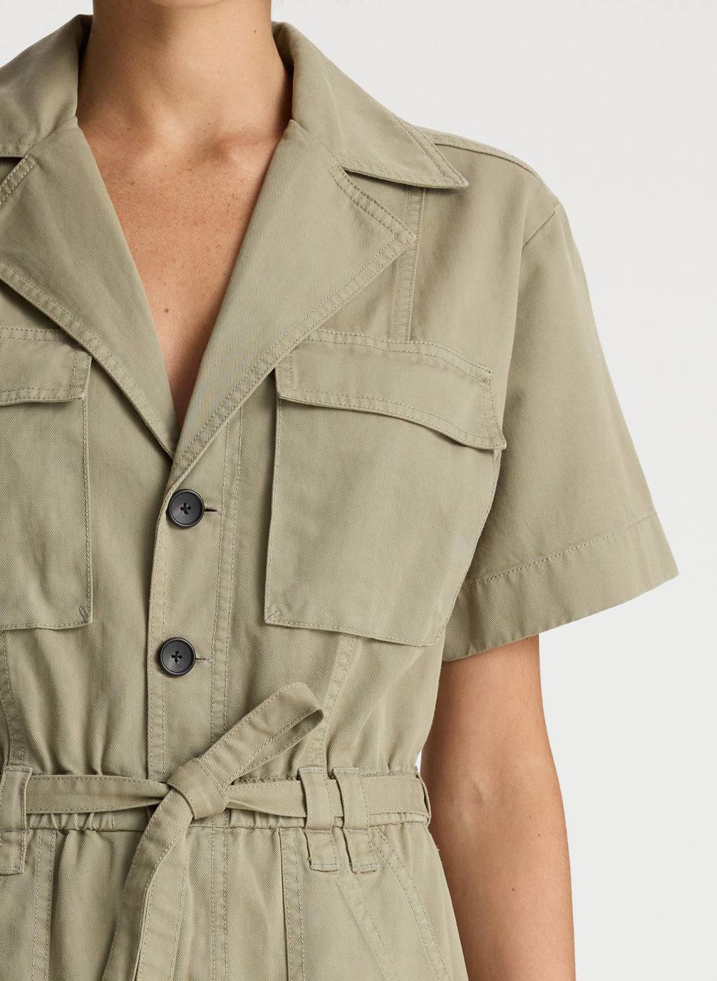 detail view of woman in short sleeve khaki jumpsuit