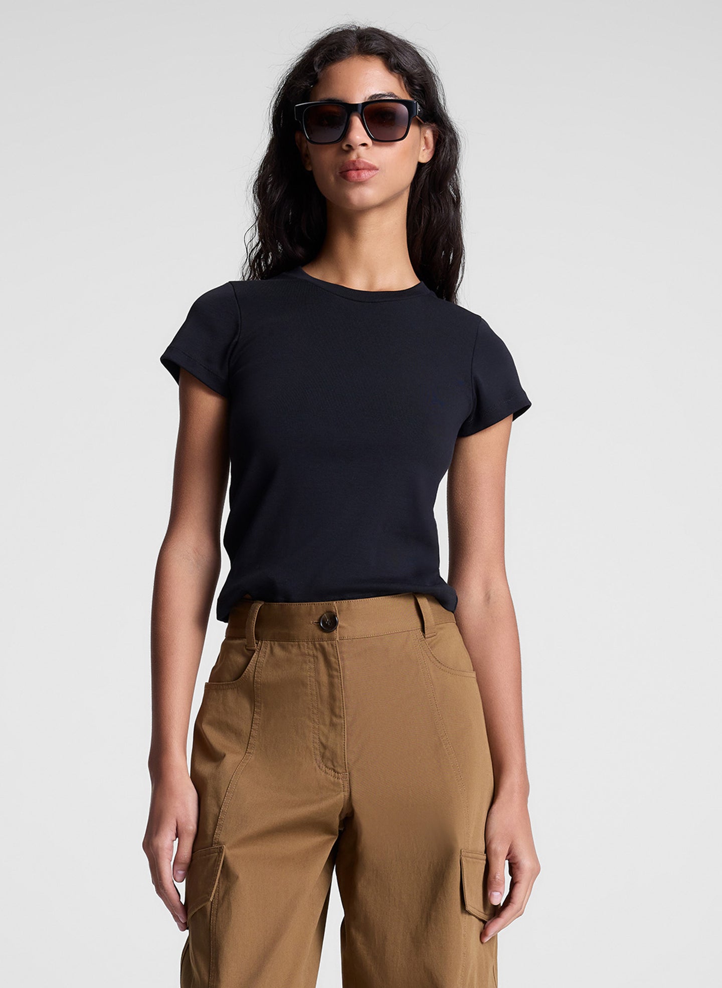 woman wearing black tee shirt and brown pants