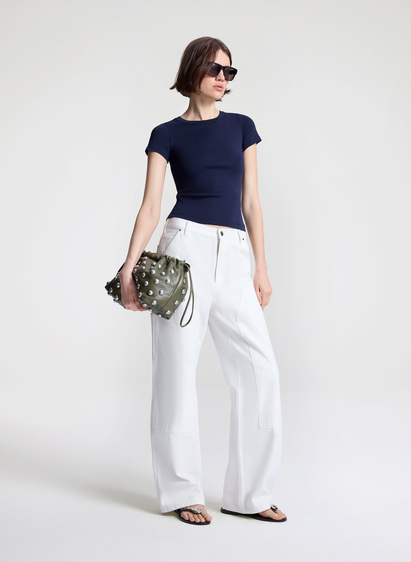 woman carrying green studded handbag