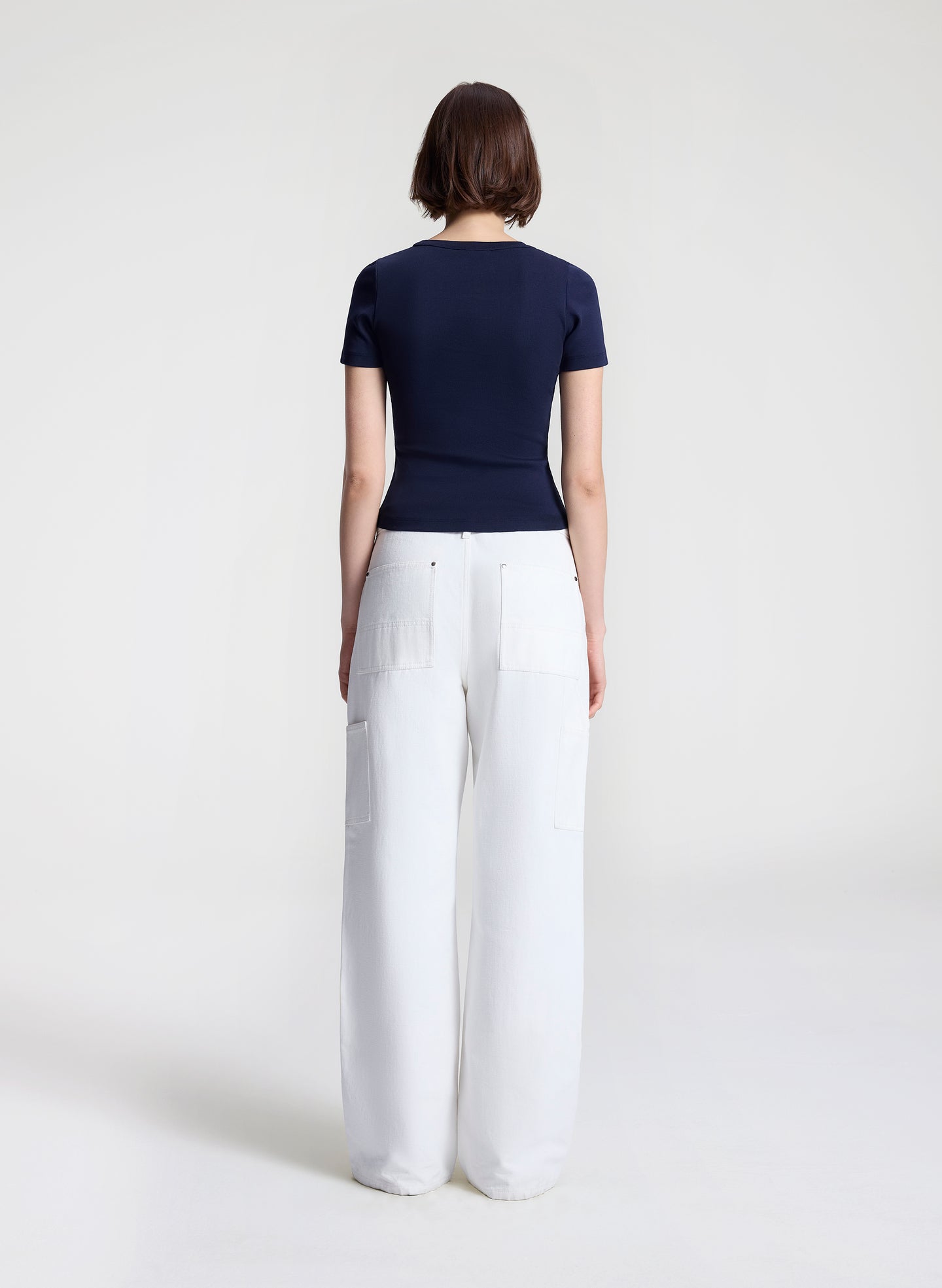 woman wearing navy blue tshirt and white denim jeans