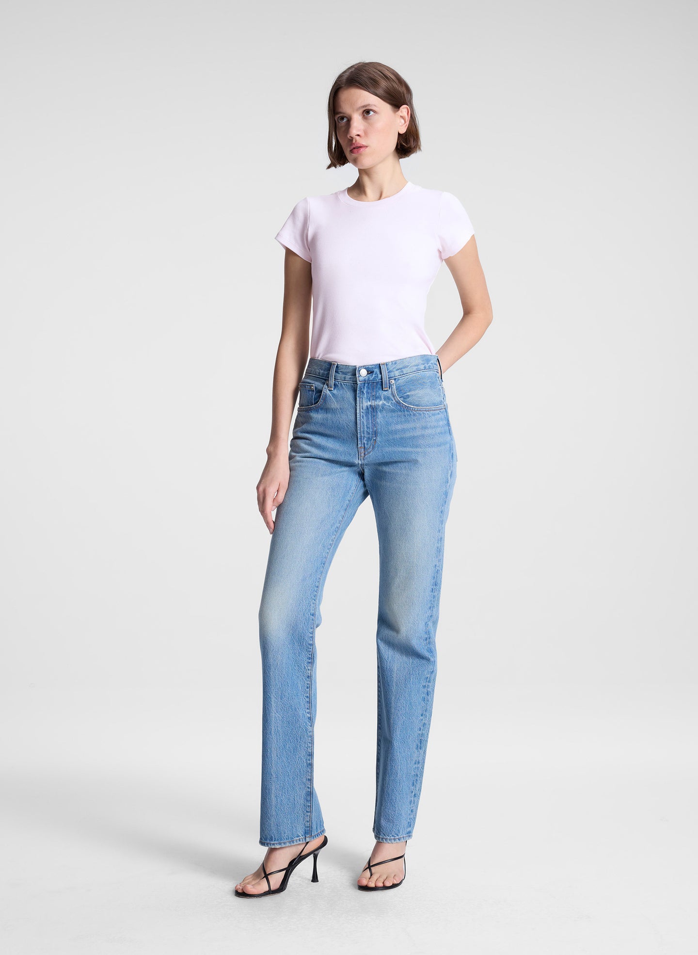 woman wearing light pink tee and light blue wash denim straight leg jeans