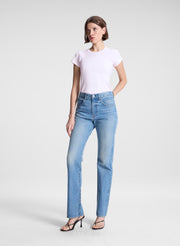 woman wearing light pink tee and light blue wash denim straight leg jeans