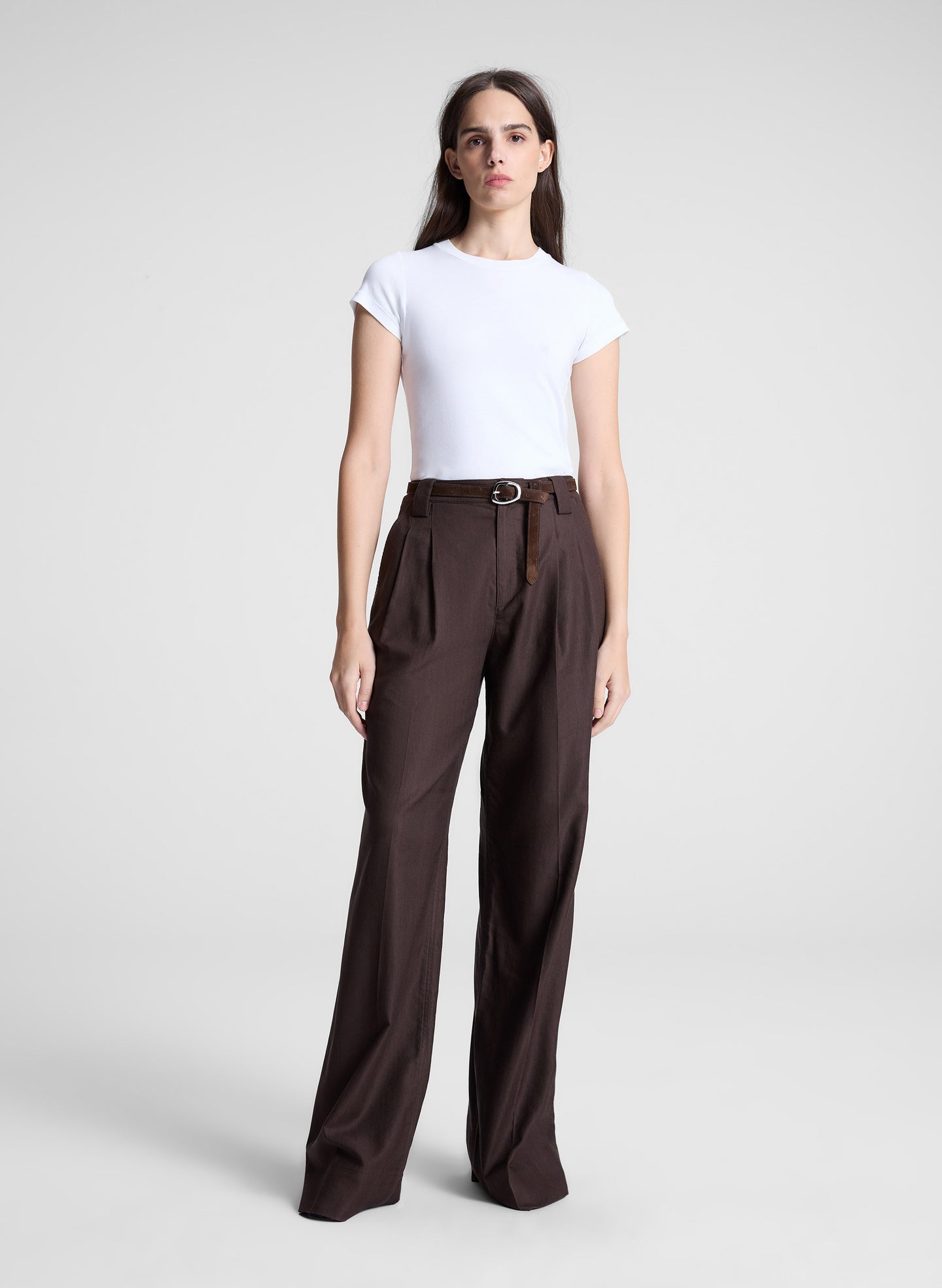 woman wearing white tshirt brown pants and brown belt