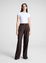 woman wearing white tshirt brown pants and brown belt