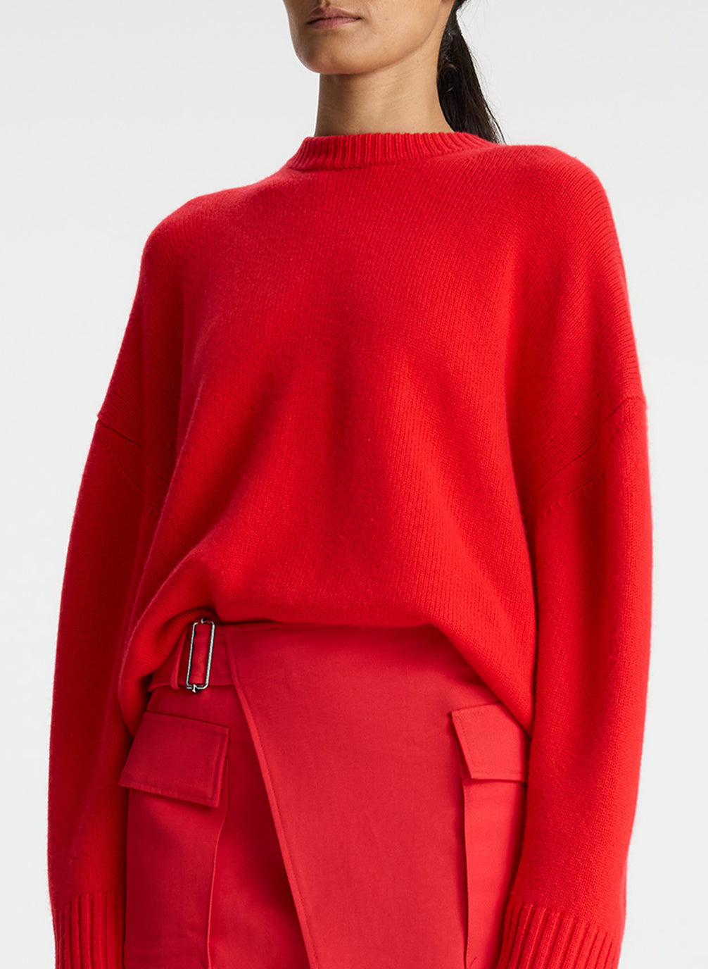 detail view of woman wearing red cashmere long sleeve sweater