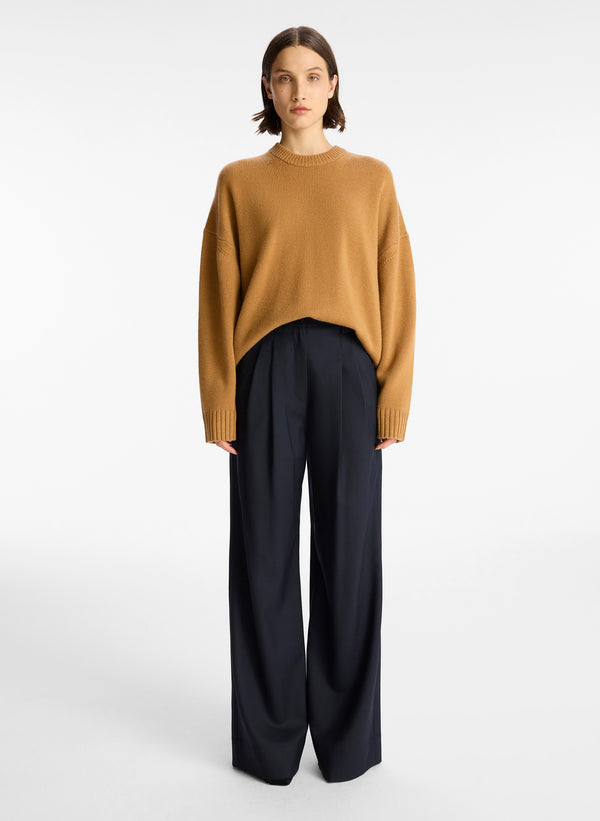 front view of woman wearing tan cashmere long sleeve sweater