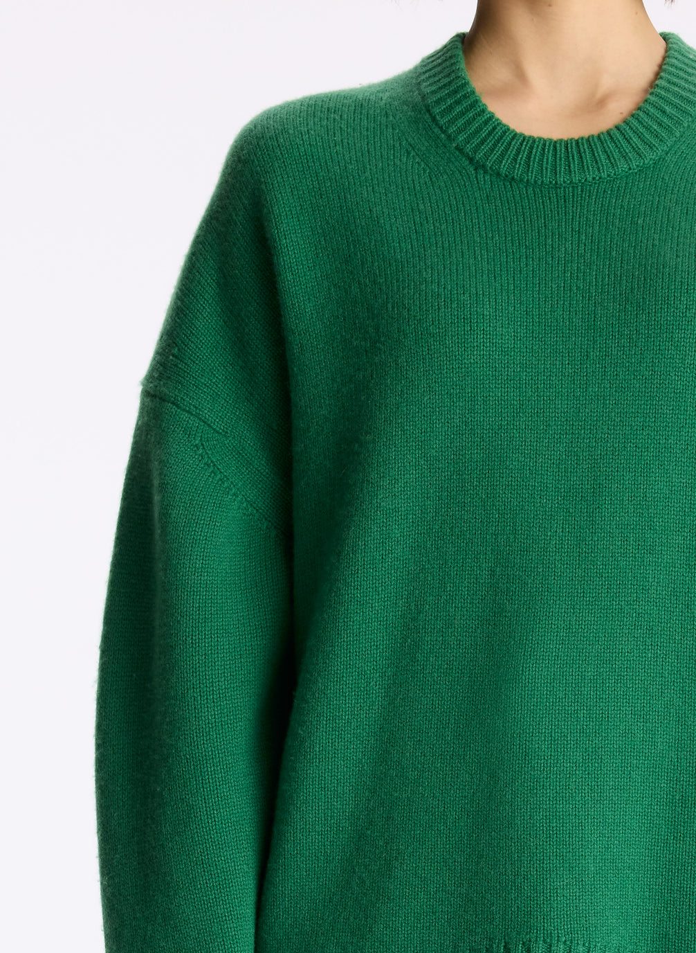 detail view of woman wearing green cashmere long sleeve sweater