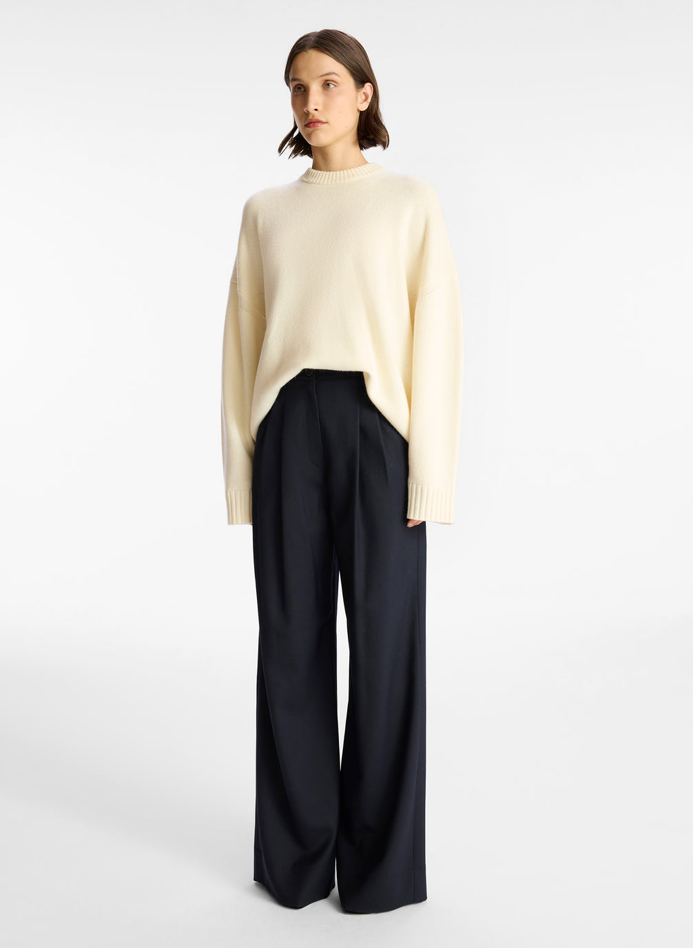 side view of woman wearing off white cashmere long sleeve sweater